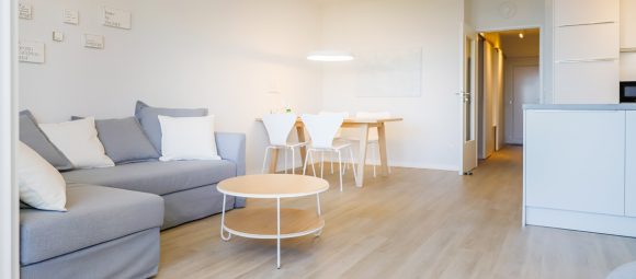 Das großzügige Wohnzimmer verfügt über eine Schlafcouch mit Sessel und einen Essbereich.