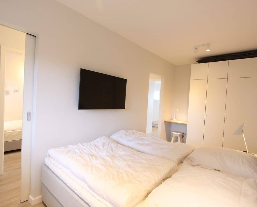 Das Schlafzimmer ist mit einem Boxspringbett (180 x 200 cm), einem Kleiderschrank und einem wandhängenden TV ausgestattet.