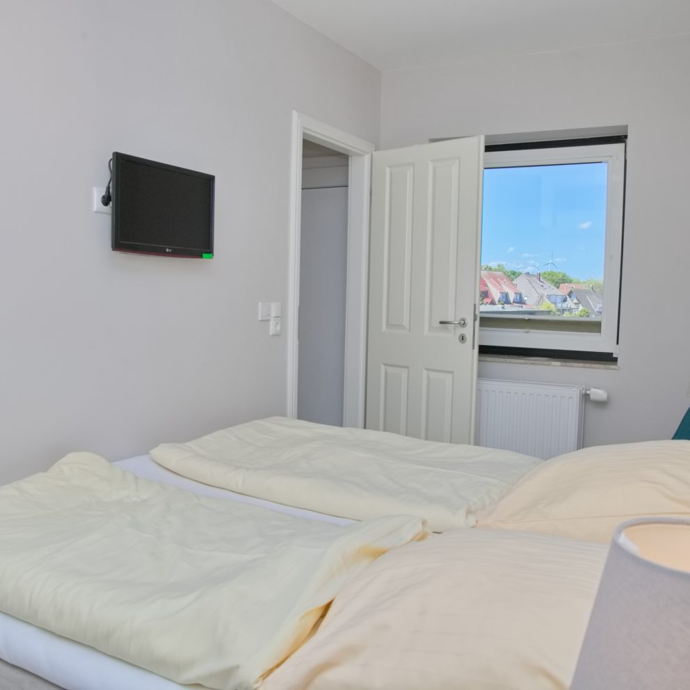 Das Schlafzimmer ist mit einem Doppelbett (180 x 200 cm), einem Kleiderschrank und einem wandhängenden TV ausgestattet.