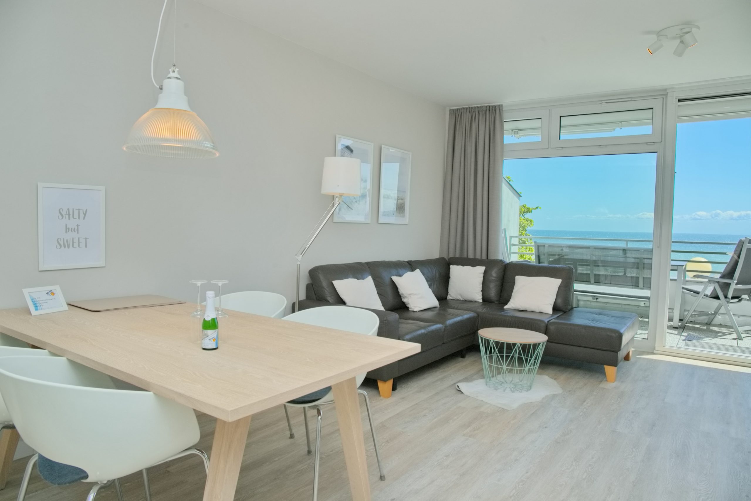 Das große Wohnzimmer mit offener Küche und Sofalandschaft hat einen herrlichen Panoramablick auf die Ostsee.
